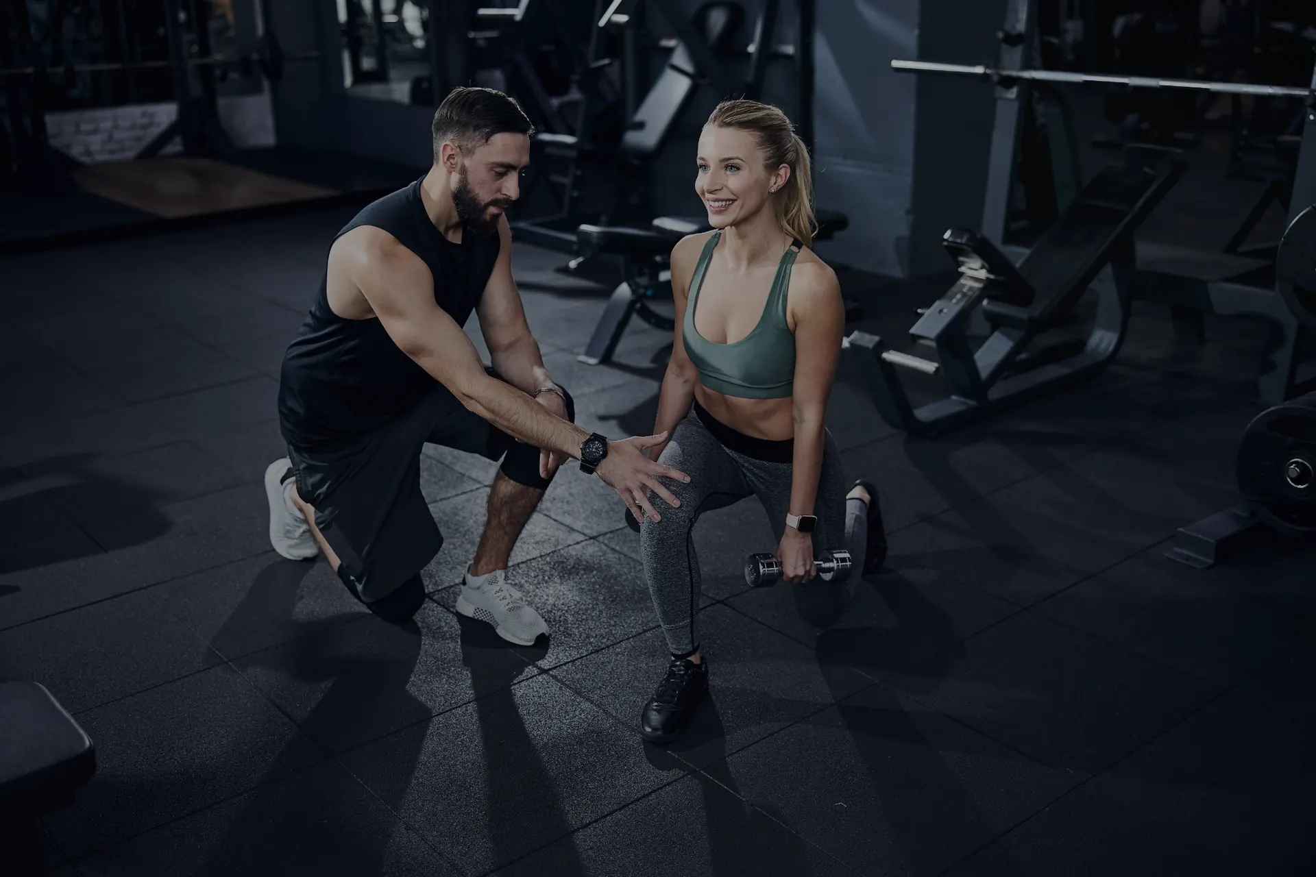 Personal trainer coaching a client in the gym