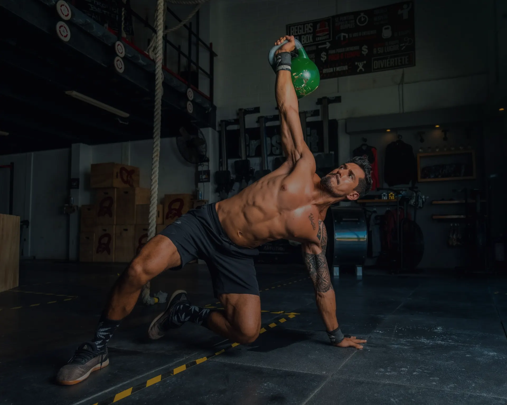 An athlete grips a barbell, chalk dust in the air.